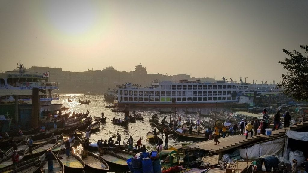 The sun is setting in the bustling Buriganga river in Dhaka, Bangladesh