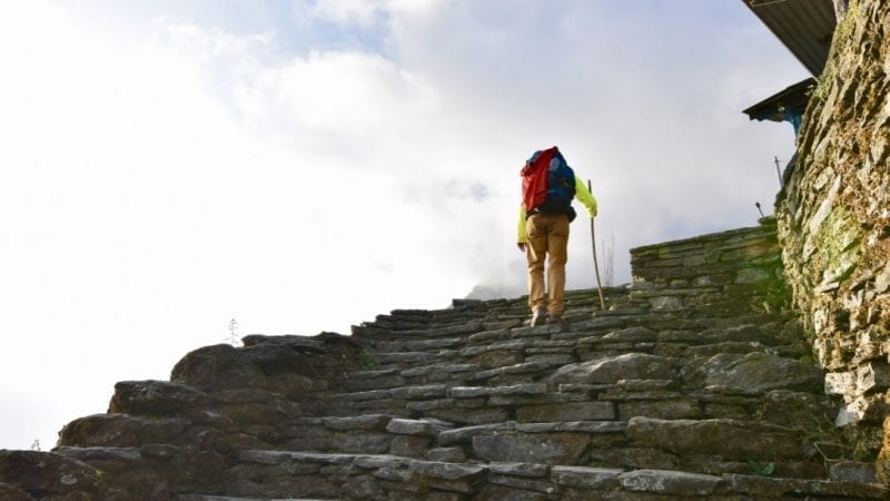 A trekker climbing stairs in Annapurna